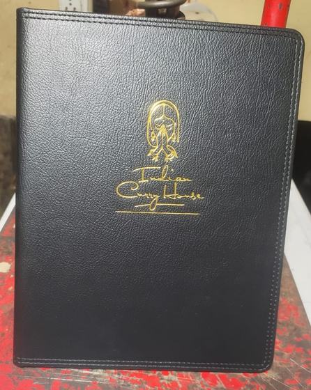 Black stitched leatherette menu cover with gold foil line art illustration and script title, custom made by RestroCart, New Delhi