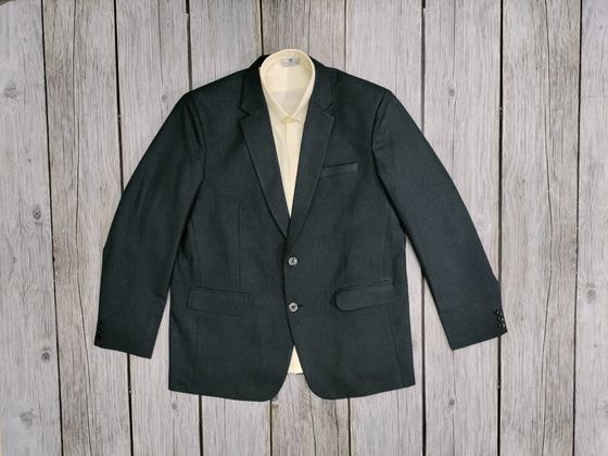 Dark green single-breasted blazer over a cream shirt, laid flat on grey wooden boards, custom made by RestroCart, New Delhi