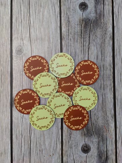 Round printed MDF coasters in brown and sage green with floral wreath script logo, scattered, custom made by RestroCart, New Delhi