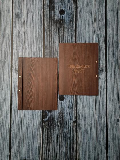 Two square dark wood MDF menu boards with brass screw posts and gold engraved script logo, custom made by RestroCart, New Delhi