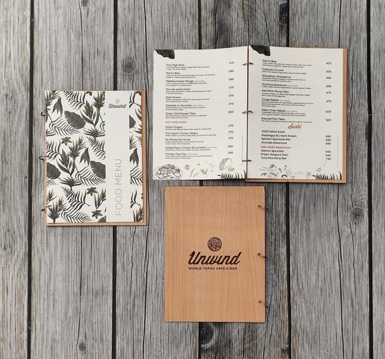 Light wood MDF menu board with engraved logo, leaf print food menu and open printed inner pages, custom made by RestroCart, New Delhi