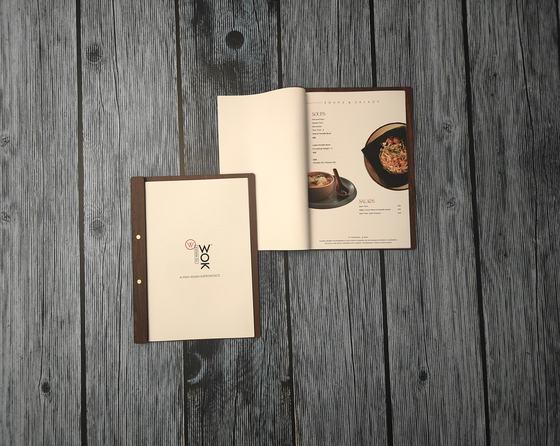 Dark wood spine menu with cream printed cover beside open inner pages showing a bowl photo, custom made by RestroCart, New Delhi