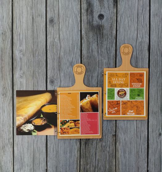 Two MDF paddle menu boards with carved handle and engraved logo holding colourful printed menus, custom made by RestroCart, New Delhi