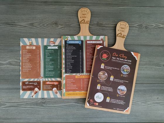 Two MDF paddle menu boards with engraved handle logo and colourful vintage style printed menus, custom made by RestroCart, New Delhi