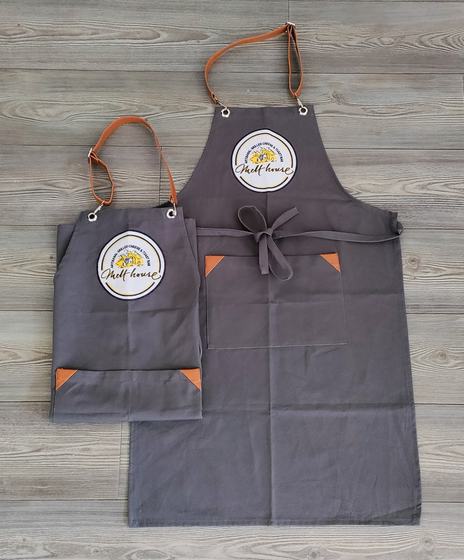 Grey canvas apron pair with tan leather straps, corner patches and round printed logo, custom made by RestroCart, New Delhi