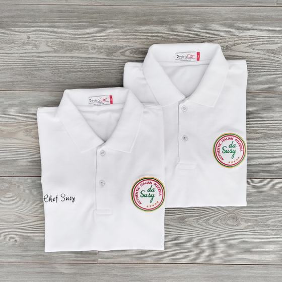 Two white polo T-shirts with round embroidered badge logo and chef name script, folded, custom made for Pizzeria Da Susy by RestroCart, New Delhi