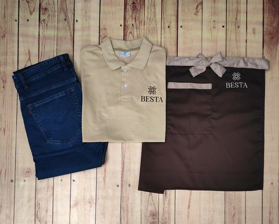 Beige polo t-shirt with embroidered logo, blue denim jeans and brown waist apron with grey trim, custom made by RestroCart, New Delhi