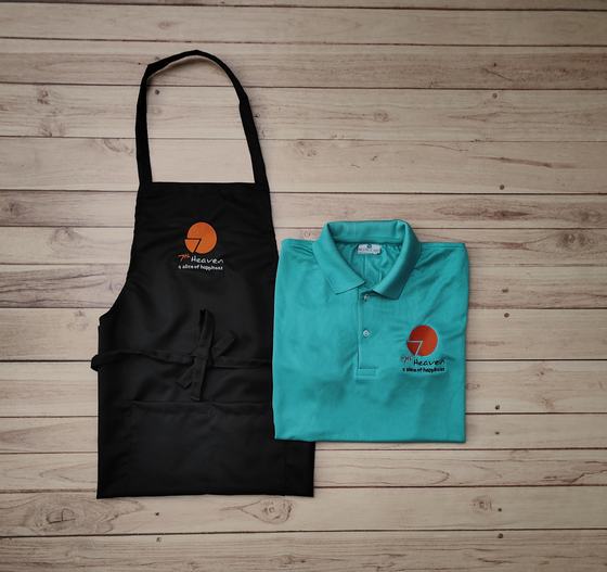 Teal green polo t-shirt with orange logo beside black bib apron with matching orange print, custom made by RestroCart, New Delhi