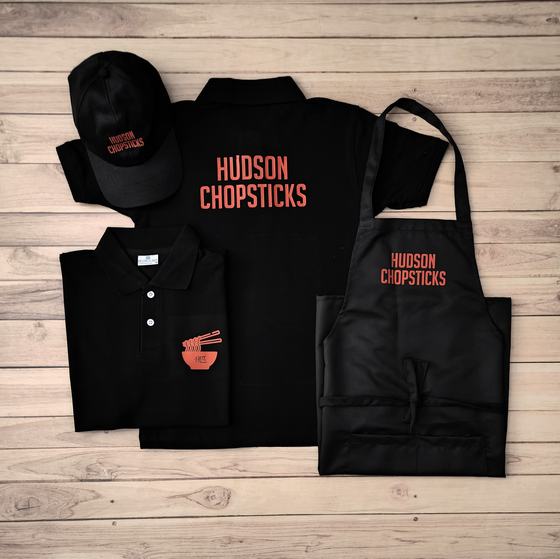 Black polo t-shirts with orange back print, black cap and black bib apron with orange lettering, custom made by RestroCart, New Delhi