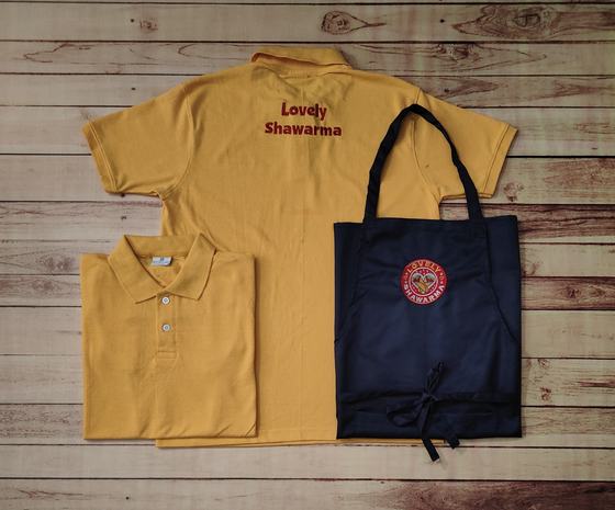 Mustard yellow polo t-shirts with red back text and navy bib apron with round red badge logo, custom made by RestroCart, New Delhi