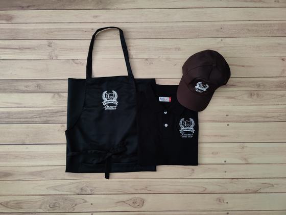 Black service set of bib apron, polo t-shirt and brown baseball cap with white embroidered crest, custom made by RestroCart, New Delhi