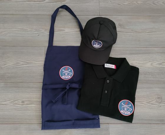 Navy bib apron, black polo t-shirt and black cap, all with round blue and white printed logo, custom made by RestroCart, New Delhi