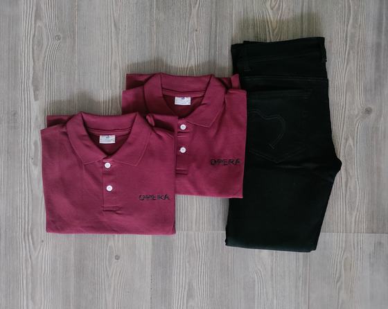 Two maroon polo t-shirts with small black embroidered text logo beside folded black trousers, custom made by RestroCart, New Delhi