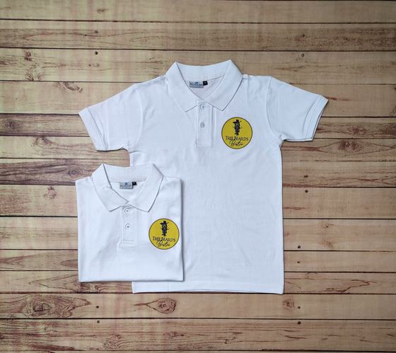 White polo t-shirts with round yellow and black printed logo patch on the chest, folded and flat, custom made by RestroCart, New Delhi
