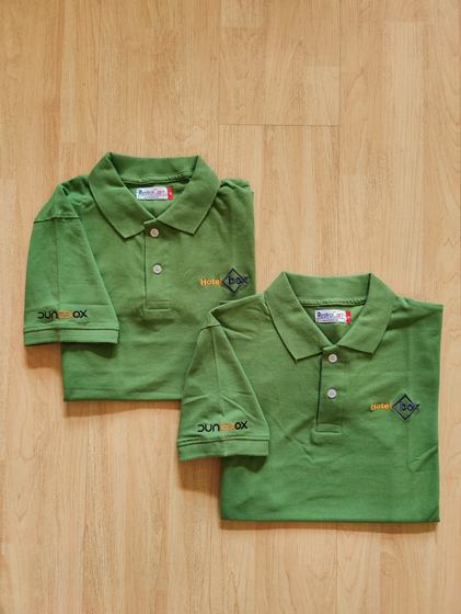 Two olive green polo t-shirts with yellow embroidered chest logo and sleeve print, folded, custom made by RestroCart, New Delhi