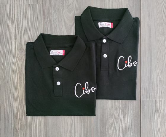 Two bottle green polo t-shirts with white embroidered script logo, folded, custom made by RestroCart, New Delhi