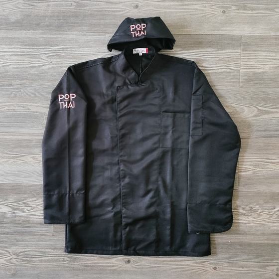 Black long sleeve chef coat with pink sleeve logo and matching black skull cap, laid flat, custom made for Pop Thai by RestroCart, New Delhi