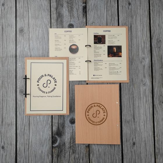 Cream printed menu with clip binding, open coffee pages and wooden cover with engraved logo, custom made for Pour & Palate by RestroCart, New Delhi
