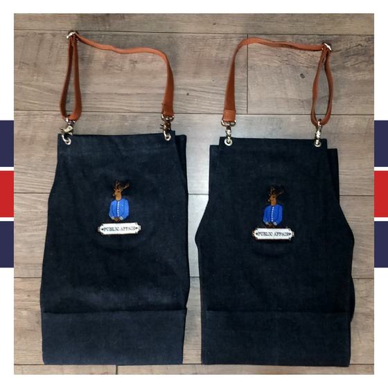Two dark denim bib aprons with brown leather straps and embroidered character logo badge, custom made for Public Affair by RestroCart, New Delhi