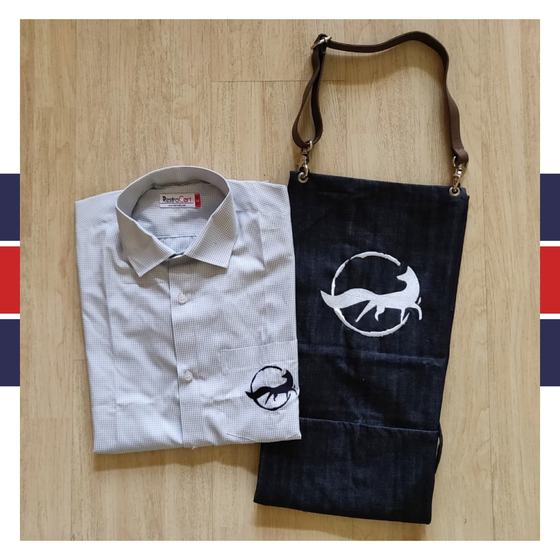 Grey shirt with fox pocket logo and dark denim bib apron with leather strap and fox print, custom made for Quick Brown Fox by RestroCart, New Delhi