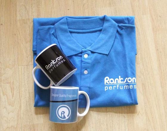 Blue polo t-shirt with printed logo and two printed ceramic mugs, laid out as a gift set, custom made for Rankson by RestroCart, New Delhi