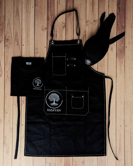 Service set of black round neck t-shirt, black cap and denim bib apron with tree logo, custom made for Rasayan by RestroCart, New Delhi