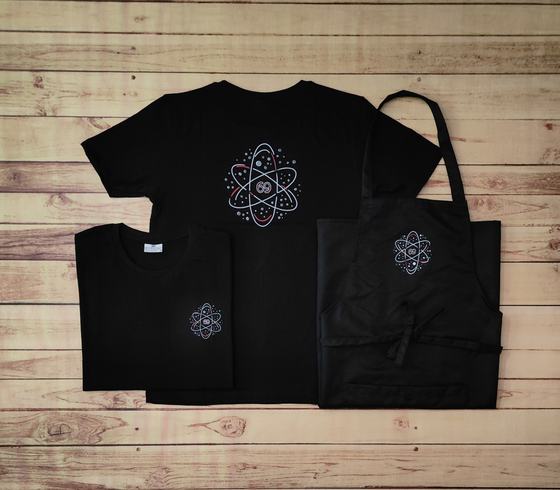 Black round neck t-shirts with pastel atom print and black bib apron with matching logo, custom made by RestroCart, New Delhi