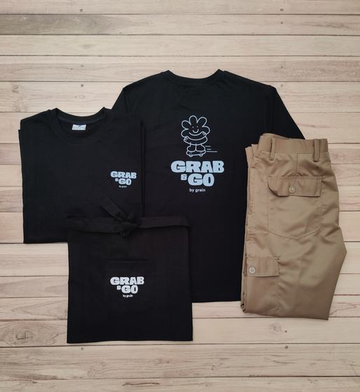 Black round neck t-shirts and waist apron with white printed mascot logo, with khaki cargo trousers, custom made by RestroCart, New Delhi