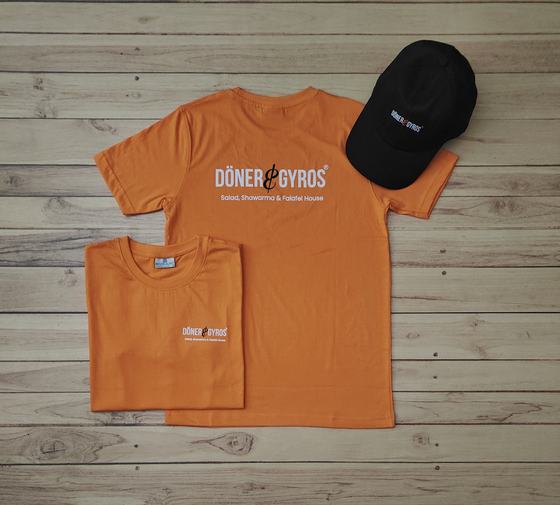 Orange round neck t-shirts with black and orange chest print and black cap with logo, custom made by RestroCart, New Delhi