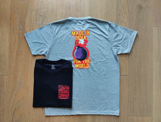 Grey round-neck t-shirt with colourful bomb graphic print and folded black tee with red logo, custom made by RestroCart, New Delhi