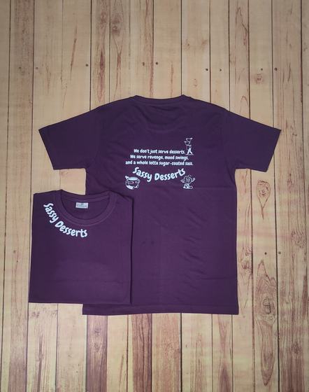 Purple round-neck t-shirts with white printed dessert slogan on the back and sleeve text, custom made by RestroCart, New Delhi