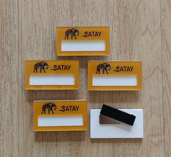 Mustard yellow acrylic name badges with elephant logo and blank white name window, custom made for Satay by RestroCart, New Delhi