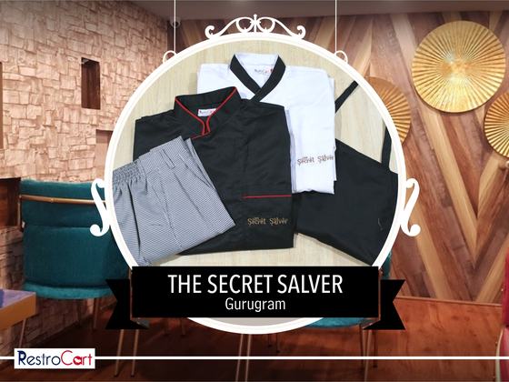 Black chef coat with red piping, white chef coat, checked trousers and black bib apron, custom made for Secret Salver by RestroCart, New Delhi
