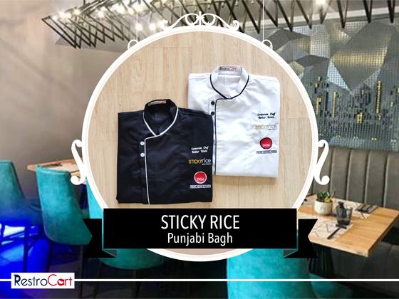 Black chef coat with white piping and white chef coat with black piping and name patch, custom made for Sticky Rice by RestroCart, New Delhi