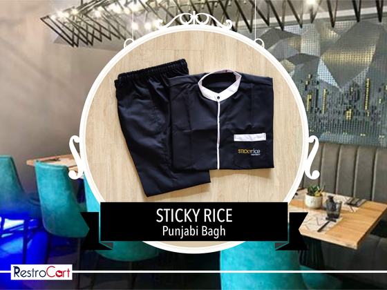 Black housekeeping tunic with white collar and placket trim and black trousers, folded, custom made for Sticky Rice by RestroCart, New Delhi
