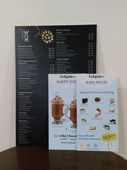 Black sunboard menu standing upright with two small printed dessert promo standees in front, custom made by RestroCart, New Delhi