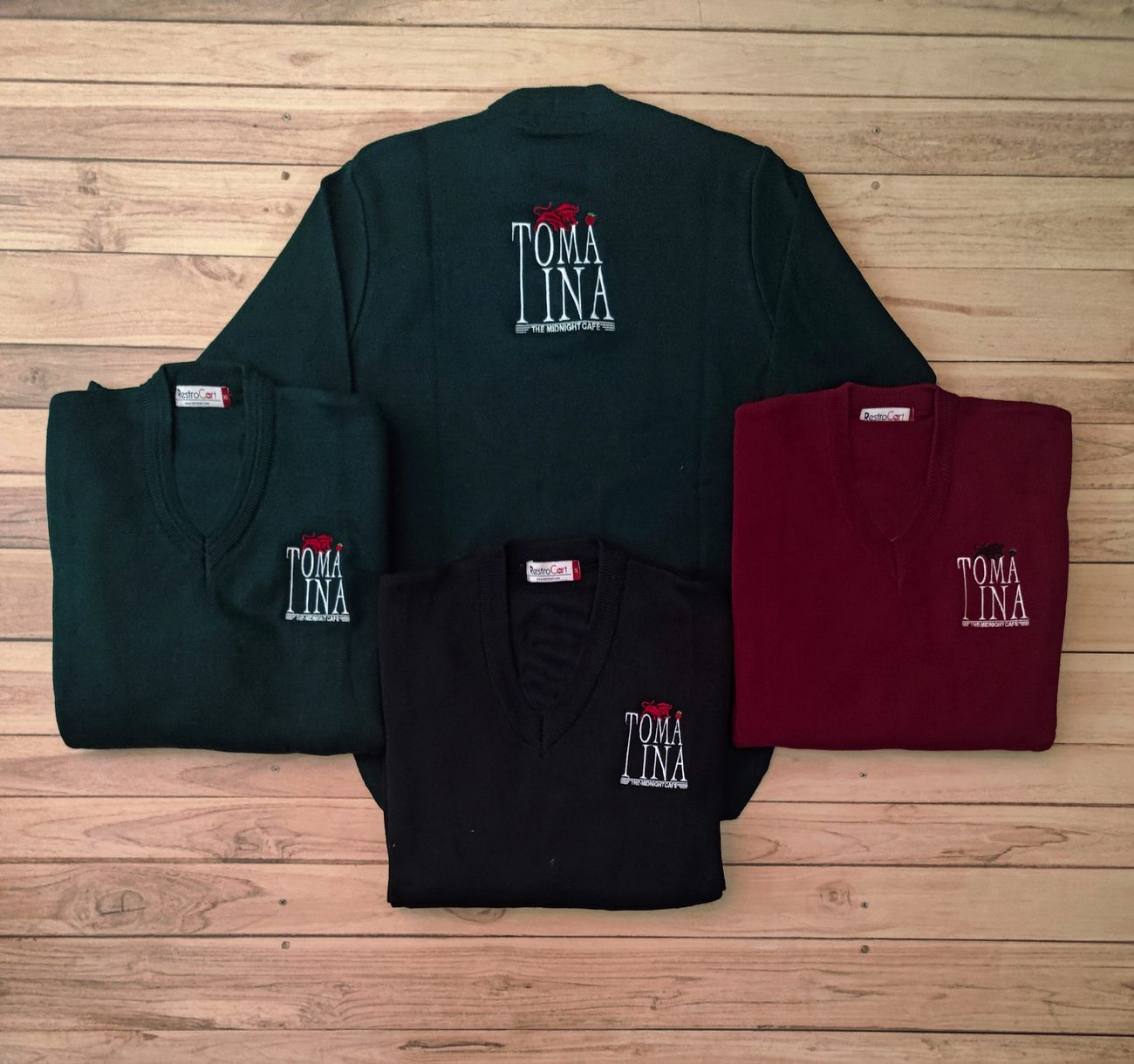 Bottle green, black and maroon knitted V-neck staff sweaters with an embroidered restaurant logo on the chest, custom winterwear by RestroCart