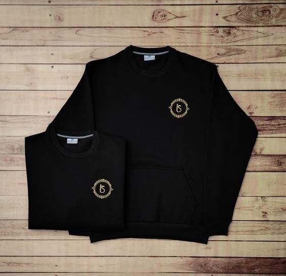 Black fleece sweatshirts with gold embroidered round monogram logo and front pocket, folded and flat, custom made by RestroCart, New Delhi