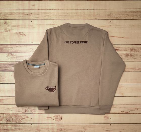 Beige fleece sweatshirts with black printed text on the back and brown coffee cup chest logo, custom made by RestroCart, New Delhi