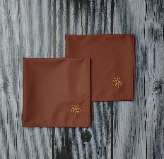 Rust brown cloth table napkins with gold embroidered flower motif in the corner, custom made by RestroCart, New Delhi