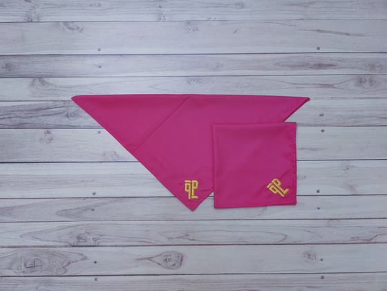 Fuchsia pink cloth table napkins with gold embroidered monogram, one open and one folded, on wood, custom made by RestroCart, New Delhi