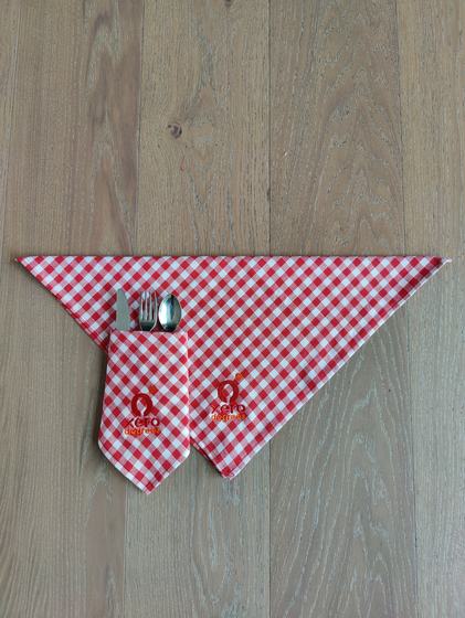 Red and white gingham table napkin folded into a cutlery pocket with fork, knife and spoon and logo, custom made by RestroCart, New Delhi