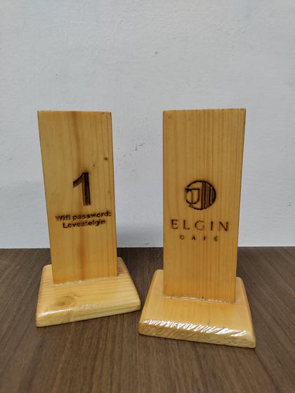 Pair of pine wood table stands, one engraved with table number and wifi details, one with cafe logo, custom made by RestroCart, New Delhi