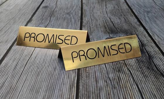 Pair of brushed gold metal tent signs with black printed lettering on a wooden table, custom made by RestroCart, New Delhi