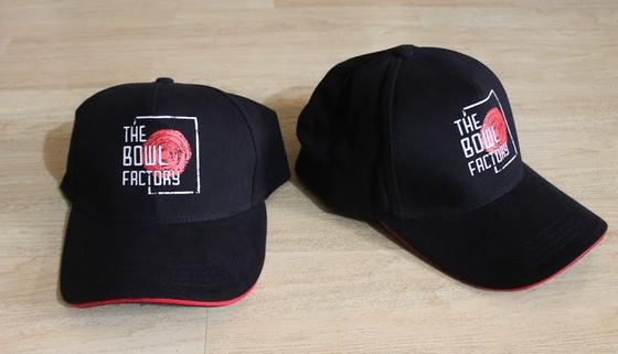 Black baseball caps with red peak trim and white and red printed logo, pair, custom made for The Bowl Factory by RestroCart, New Delhi