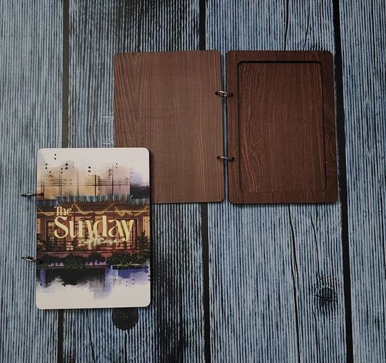 Dark walnut MDF ring-bound menu cover opened flat beside a printed photo menu insert, custom made for The Sunday House by RestroCart, New Delhi