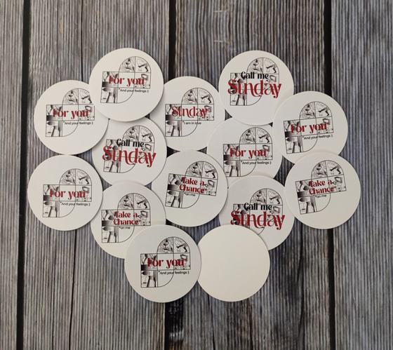 Round white paper coasters with red script and photo prints, scattered on dark wood, custom made for The Sunday House by RestroCart, New Delhi