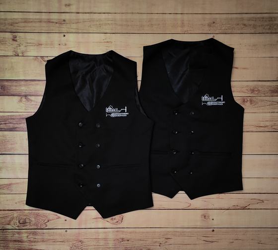 Pair of black V-neck waistcoats with white embroidered skyline logo and lining, laid flat on wood, custom made by RestroCart, New Delhi