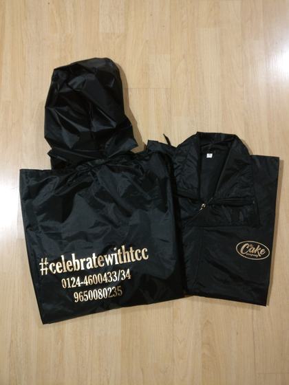Black hooded raincoat with gold printed hashtag and phone numbers, and zip jacket, custom made by RestroCart, New Delhi