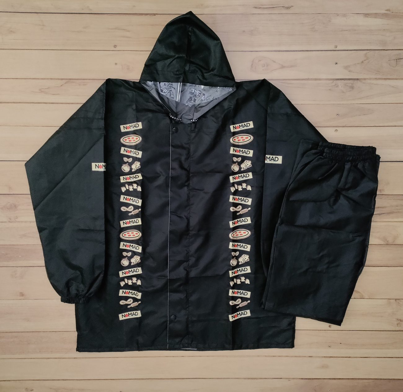 Black hooded rain jacket with matching rain trousers, printed lining and a vertical band of restaurant logos down both front panels, custom monsoon rainwear by RestroCart
